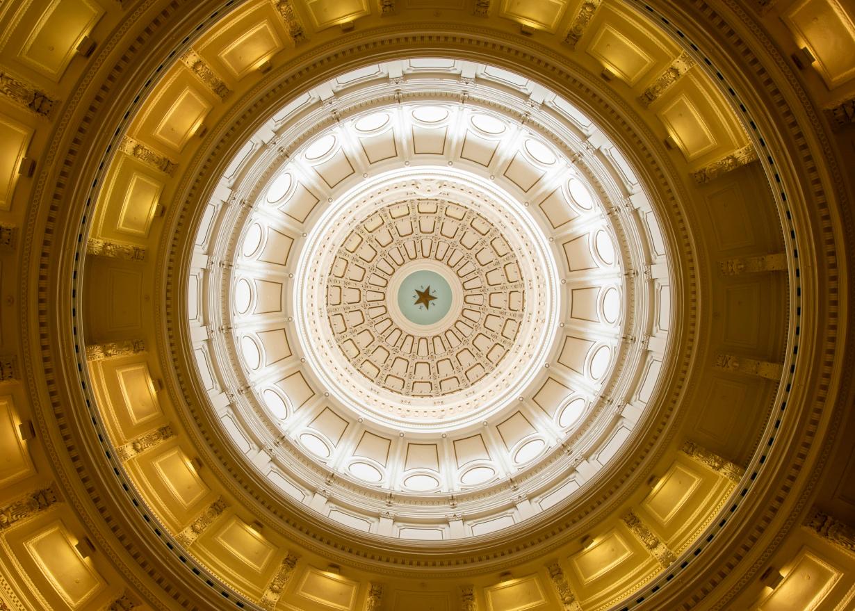 Looking up at the ceiling of the Texas Capitol rotunda dome with the star of Texas.
