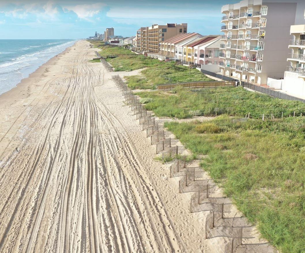 Down beach view of Dune Restoration with ocean on left and dunes and hotels on the right.