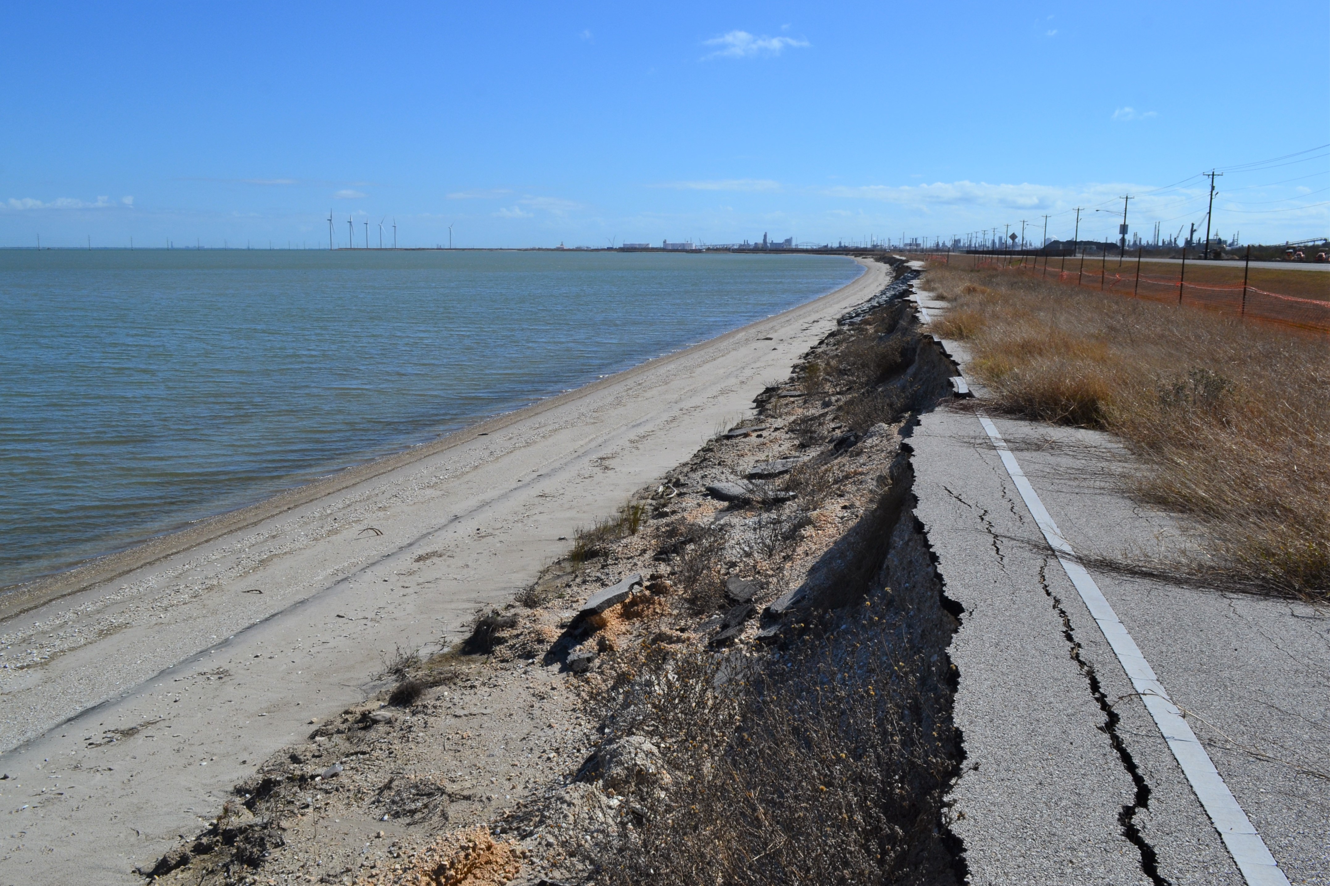 Eroding coast line with ocean on the left and eroding street on the right.