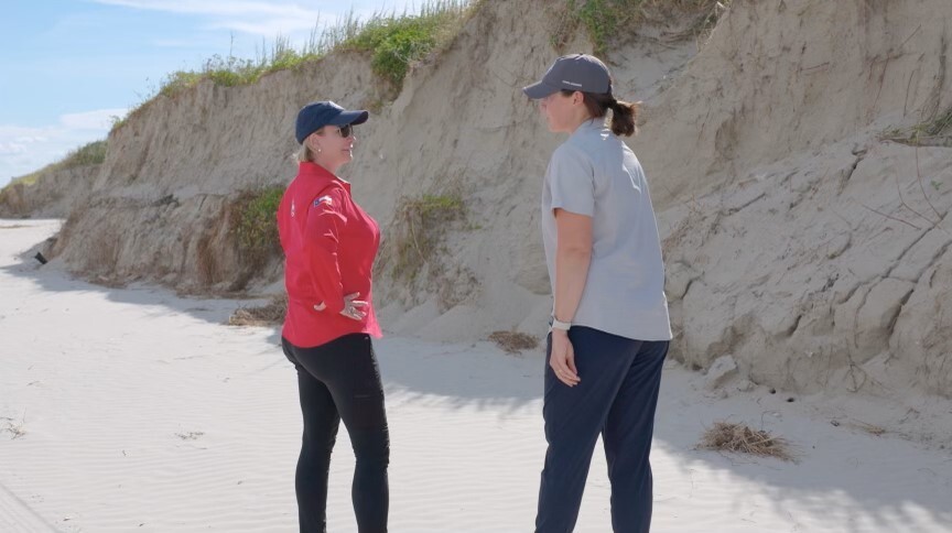 Commissioner talking with an official at the beach.