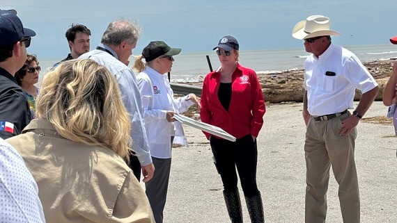 Commissioner talking with officials at the beach.