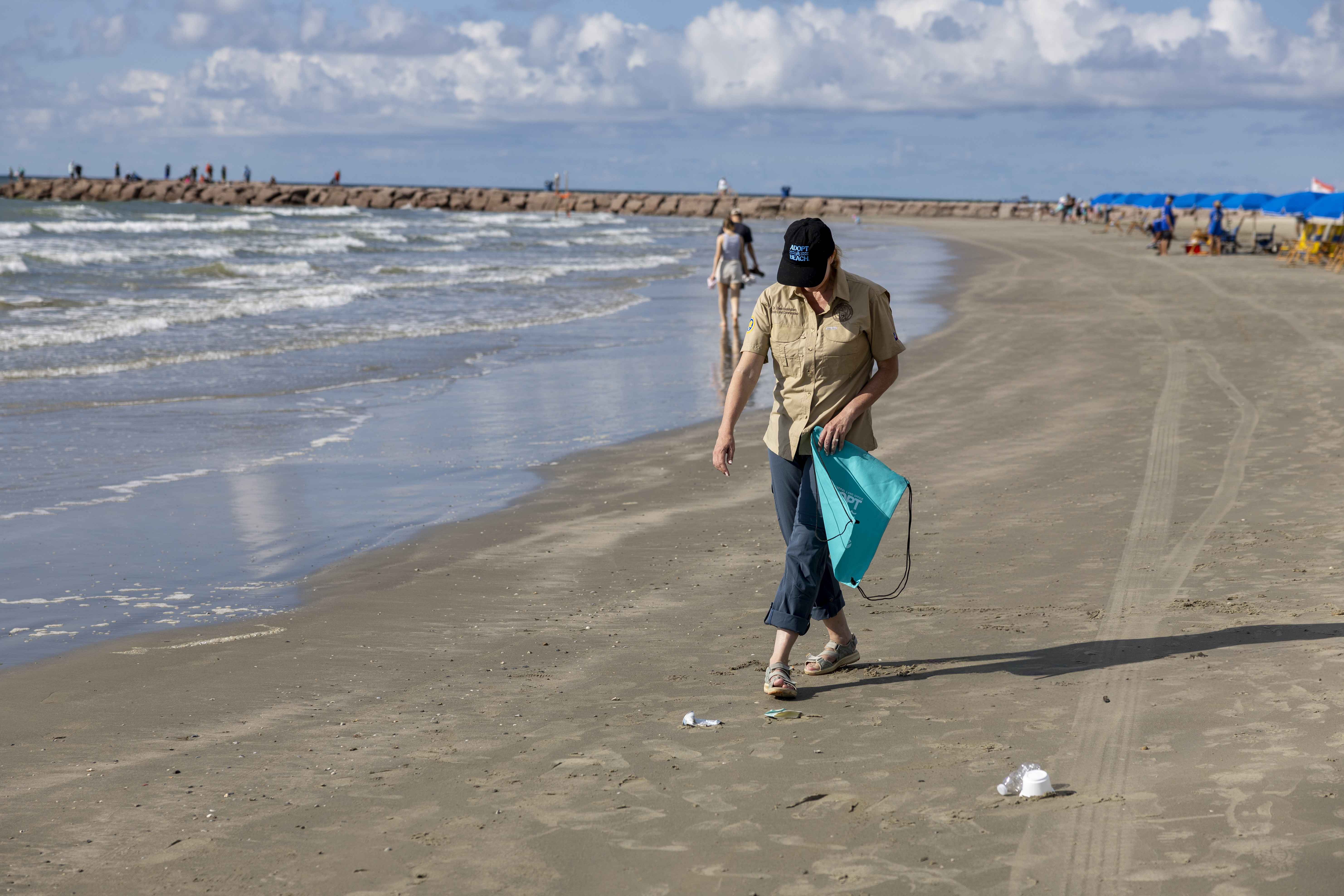 Commissioner Dawn Buckingham M.D. picking up trash in a Texas Adopt-A-Beach hat.