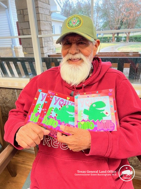 A Texas State Veterans Home resident poses with Valentines for Vets cards