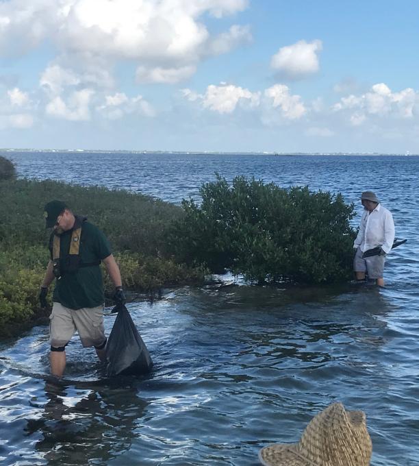 2 people cleaning up the coast.