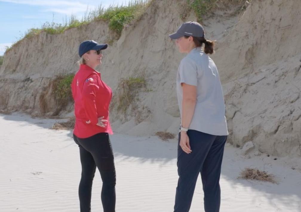 Commissioner talking with an official at the beach.